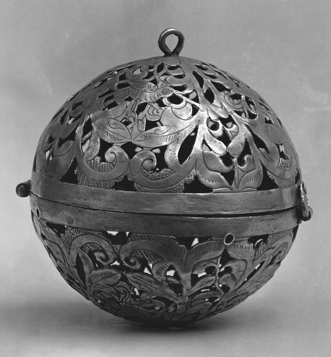 A spherical silver censer with pierced bird and foliage decoration and a small suspension loop, in a black-and-white museum photograph.